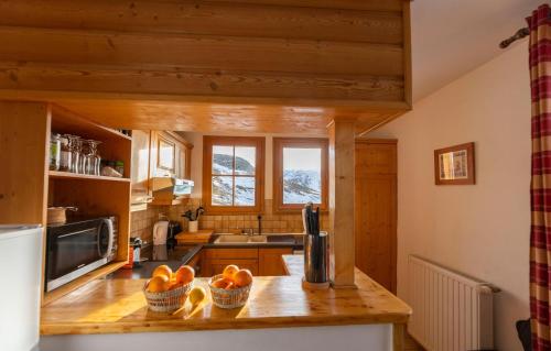 une cuisine avec un comptoir avec des oranges dans des paniers dans l'établissement Odalys Chalet Diane, à L'Alpe-d'Huez