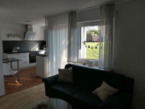 - un salon avec un canapé et une fenêtre dans l'établissement Ferienwohnung Schneckenhaus, à Ofterdingen