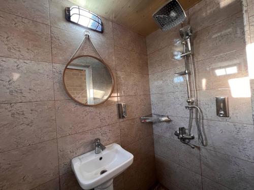 y baño con lavabo, espejo y ducha. en Lakeside Garden - Ismayilli Guest house, en İsmayıllı