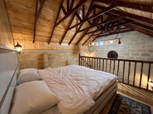 a large bed in a room with wooden ceilings at Lakeside Garden - Ismayilli Guest house in İsmayıllı