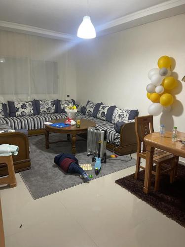 ein Wohnzimmer mit einem Sofa, einem Tisch und Ballons in der Unterkunft Beautiful Rooms in Ben Guerir in Benguerir