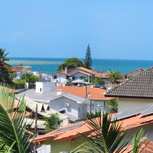 a view of roofs of houses and the ocean at Casa Arrô - Pousada Boutique in Itajaí