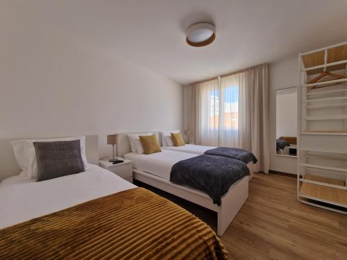 Cette chambre comprend 2 lits et une fenêtre. dans l'établissement Funchal Downtown Flats 2, à Funchal