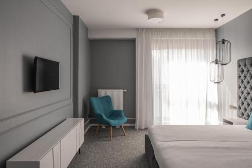 a bedroom with a bed and a blue chair at City Inn Lviv Smart Hotel in Lviv