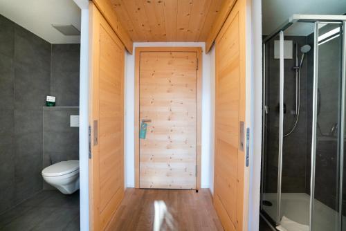 JaunにあるHotel Wasserfallのバスルーム(トイレ付)、木製のドアが備わります。
