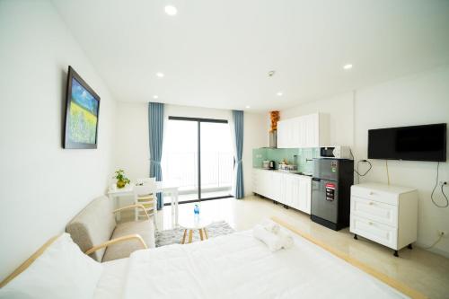 een woonkamer met een witte bank en een keuken bij Vinhomes D’capitale studio in Hanoi