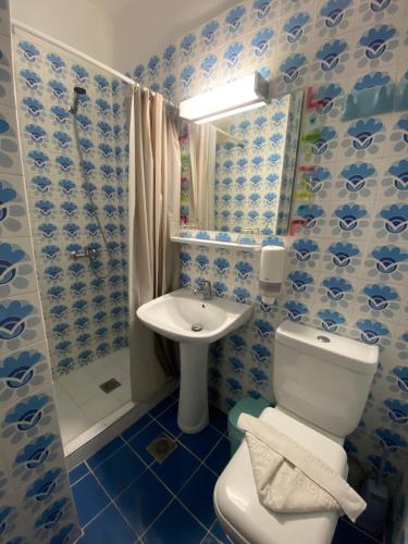 a blue and white bathroom with a toilet and a sink at Paradise Hotel in Kos Town