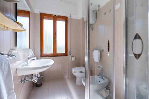 bagno bianco con lavandino e servizi igienici di Residence Oasis ad Alghero