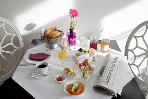 a table with breakfast foods and coffee on it at Alte Apotheke Bed & Breakfast in Karlsbad