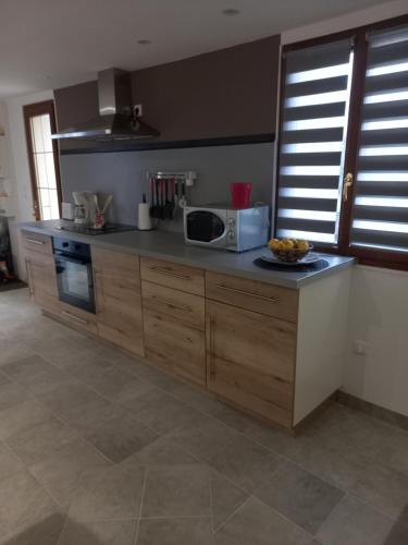 une cuisine avec un comptoir avec un micro-ondes dans l'établissement Gîte LA FONTAINE DU MARAIS, à Pendé