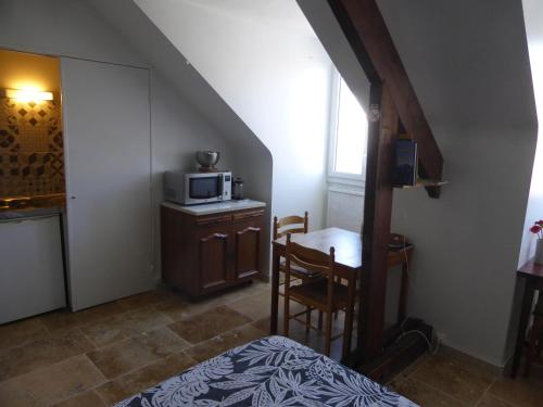 une chambre avec un lit et une table avec un micro-ondes dans l'établissement Studio calme au coeur de Tours, à Tours