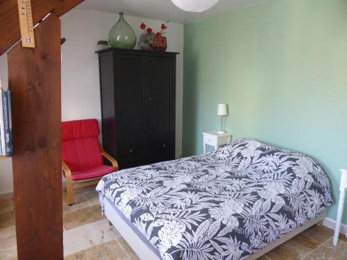 a bedroom with a bed and a red chair at Studio calme au coeur de Tours in Tours