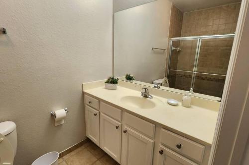 a bathroom with a sink and a mirror and a toilet at Apartment Kissimmee - Orlando in Kissimmee