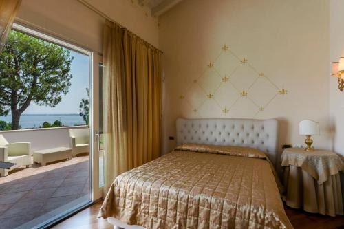 a bedroom with a bed and a large sliding glass door at VILLA ELENA in Moniga