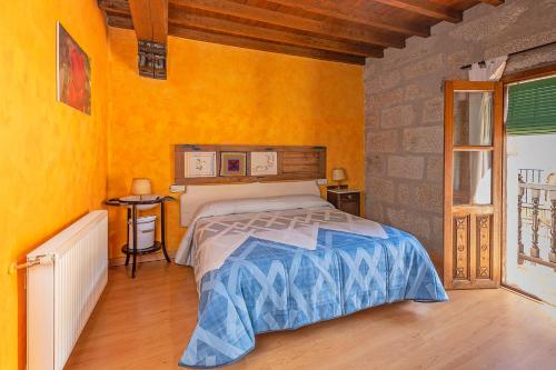 a bedroom with a bed in a room with yellow walls at Antigua Posada, Valle del Jerte in Tornavacas