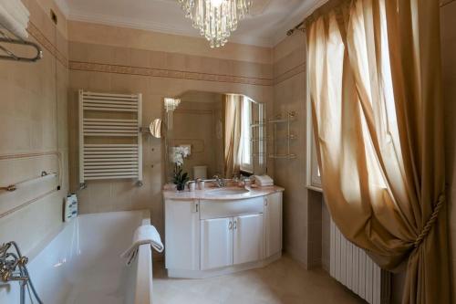 y baño con bañera, lavabo y espejo. en VILLA ELENA, en Moniga del Garda
