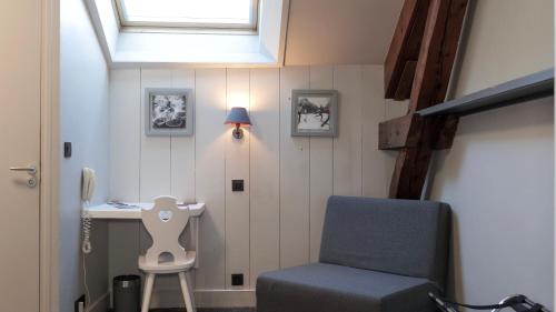 a room with a chair and a desk and a window at Le Faucigny - Hotel de Charme & SPA in Chamonix-Mont-Blanc