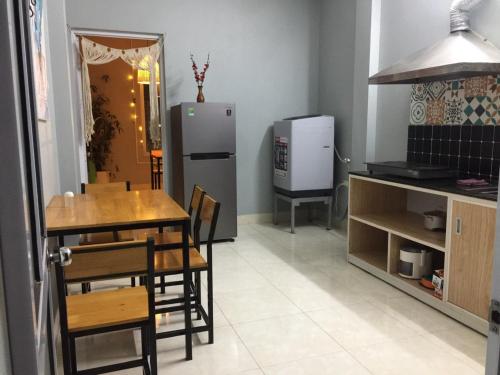 a kitchen and dining room with a table and a refrigerator at VietHouse Homestay Ha Long in Ha Long