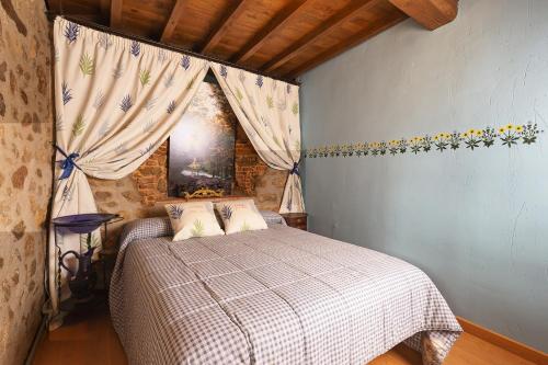 a bedroom with a bed and a window with curtains at Antigua Posada, Valle del Jerte in Tornavacas
