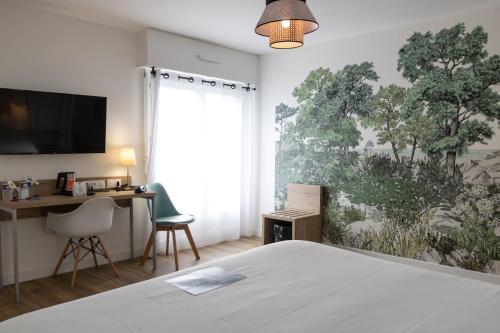 a bedroom with a bed and a desk and a tv at Logis Golfe Hotel in Vannes