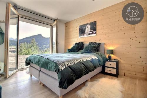 um quarto com uma cama e uma grande janela em Chalet La Luna, Mayens-de-Chamoson em Chamoson