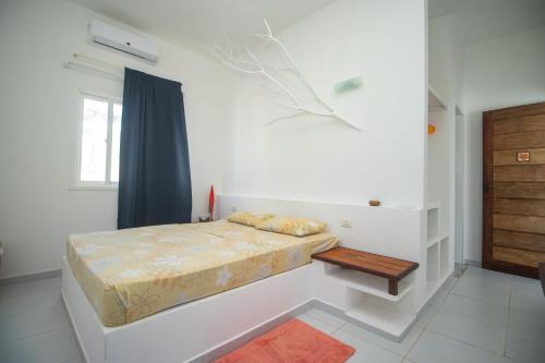a white bedroom with a bed and a table at Casa Incrível na Praia de Jacumã por Carpediem in Ceará-Mirim