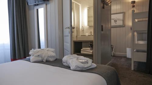 a hotel room with a bed with towels on it at Le Faucigny - Hotel de Charme & SPA in Chamonix-Mont-Blanc