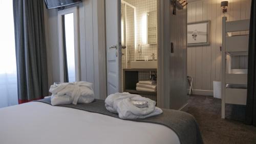 a hotel room with a bed with towels on it at Le Faucigny - Hotel de Charme in Chamonix