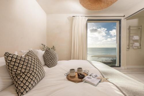 a bedroom with a bed with a view of the ocean at Little Cottage in Praa Sands