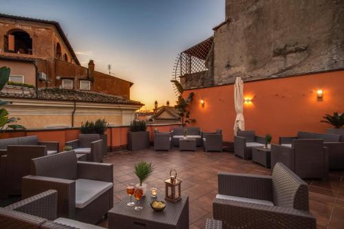 a patio with chairs and tables on a building at Tritone Top House in Rome