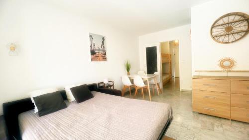 une chambre avec un lit, une table et des chaises dans l'établissement Le Magali, à Villeneuve-Loubet