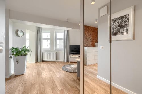 salon z białymi ścianami i drewnianą podłogą w obiekcie Apartamenty MUNN 6 Szczecin w Szczecinie
