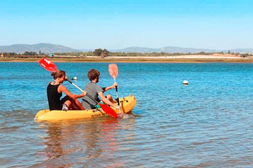 two people are riding on a raft in the water at Wax Hostel in Faro