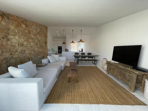 uma sala de estar com um sofá branco e uma televisão de ecrã plano em Alvor River & Sea View em Alvor