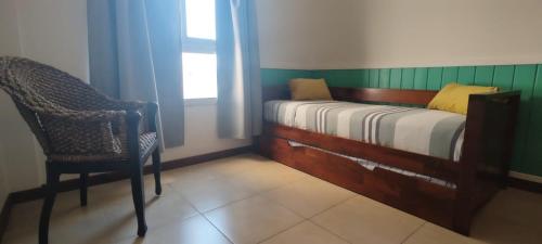 1 dormitorio con 1 cama, 1 silla y 1 ventana en Mi casa, tu casa cambacua cochera en Corrientes