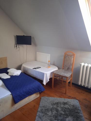 a small room with two beds and a chair at Agroturystyka Na górce in Uszyce