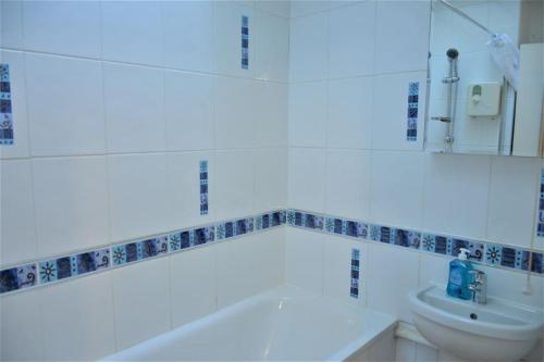 a bathroom with a tub and a toilet and a sink at London Zone 2, 2 Bedroom House in London