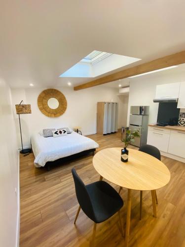 a bedroom with a bed and a table and a kitchen at Les studios de Morgane hyper centre in Valence