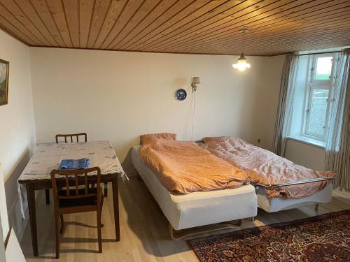 a bedroom with a bed and a table with a chair at Toppenbjerg's B&B in Vestervig