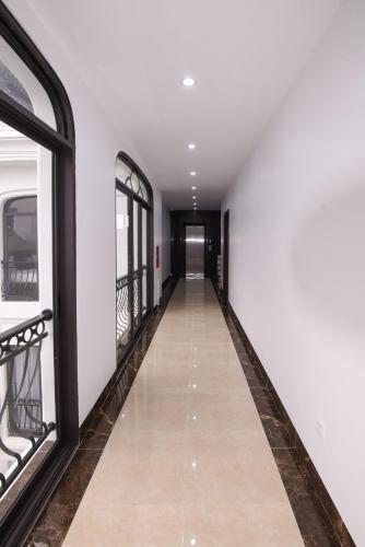 a corridor with white walls and a hallway with windows at Lotus Hotel Ninh Bình in Ninh Binh