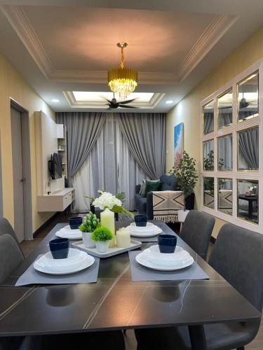 una sala da pranzo con tavolo e un soggiorno di Casa Nabila Bandar Baru Bangi a Bangi