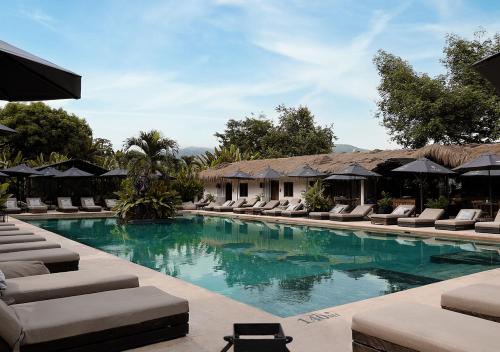 a swimming pool with lounge chairs and umbrellas at Hotel Casa Candela in San Jerónimo