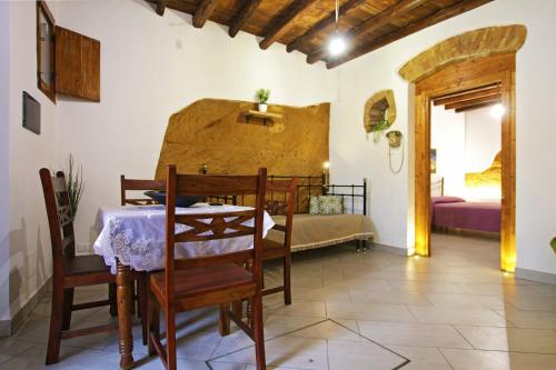 a dining room with a table and a bedroom at Rabatè in Agrigento