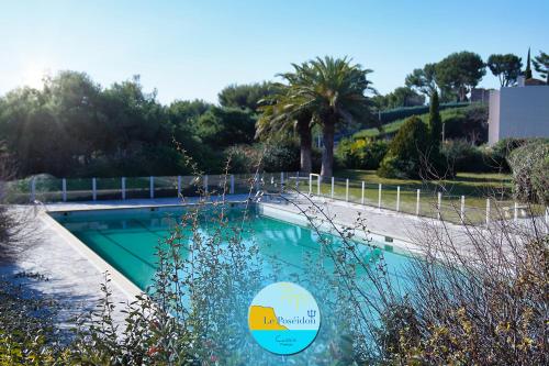 una piscina en un patio con una palmera en LE POSEIDON VUE MER en Cassis