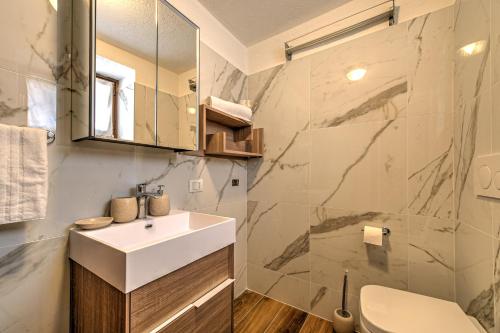 Maison Elodie في كورمايور: حمام مع حوض ومرحاض ومرآة