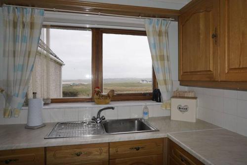a kitchen with a sink and a window at Mackenzie 25 in Stornoway