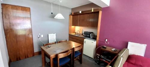 a kitchen with a table and a purple wall at Departamento Penitentes Lomas Blancas in Los Penitentes