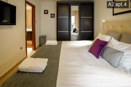 a large white bed with two pillows on it at Palmore Resort apartments in Eilat
