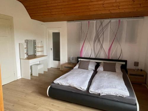 een slaapkamer met een groot bed met roze koorden aan de muur bij Camping Waldfrieden in Saarburg