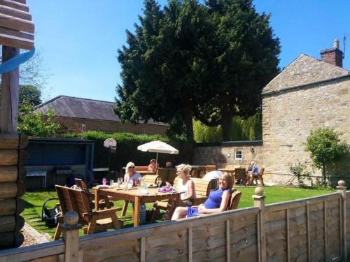 a group of people sitting at a table in a yard at The Manners Pub with Rooms in Bakewell